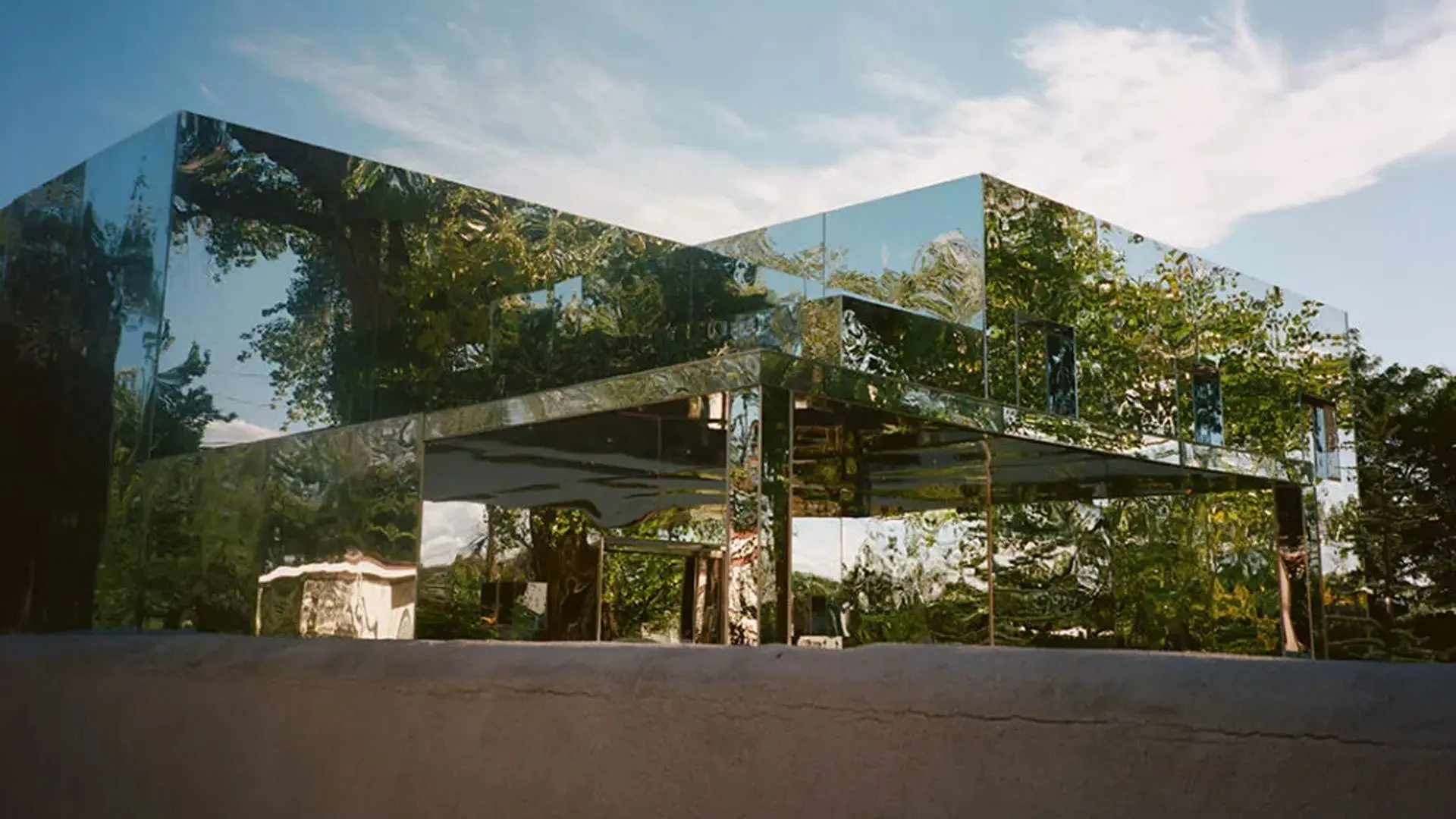 یک خانه‌ که نمای آن را صفحاتی آیینه‌گون تشکیل داده‌اند در نمایی از سریال نفرین به کارگردانی نیتن فیلدر